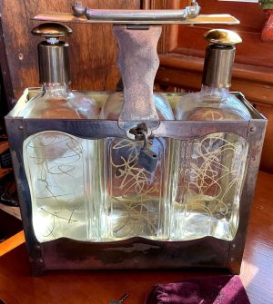 Tilso tantalus:3 decanters w gold swirls. Locks,key included. Music box plays”How Dry I Am.” (Needs adjustment.) Brass and glass.Free ship.