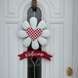 Lovely daisy with red/white checkerboard heart and “Welcome” banner in sturdy metal with hangers for your door. 18”by 12.” Free shipping.